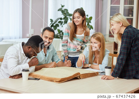 Diverse multiracial students spending leisure time in library with big old book 67437426