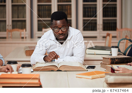 African american male college studen preparing for exams in the library. 67437464