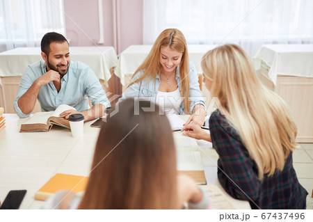 Group of multiracial people studying with books in college library. 67437496