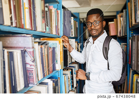 African american male college student preparing for exams in the library. 67438048
