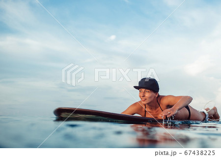 Beautiful girl posing sitting on a surfboard in Beautiful girl posing sitting on a surfboard in 67438225