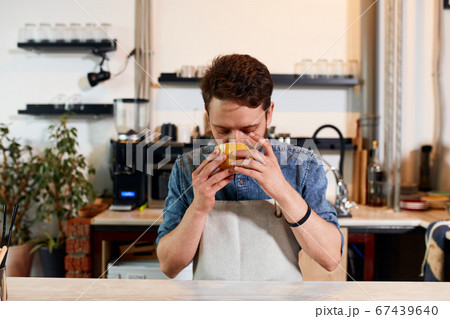 Confident self assured barista at bar counter 67439640