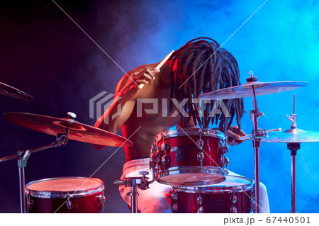 portrait of professional drummer man isolated in smoky space 67440501