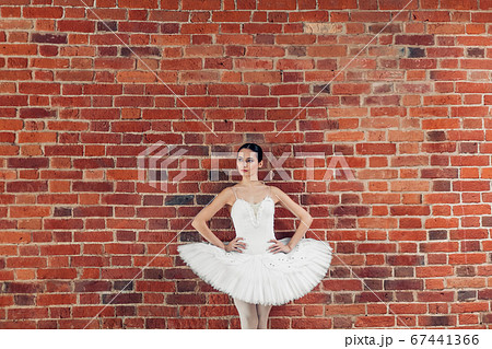 thoughtful serious dancer in fashion outfit standing over the loft wall 67441366