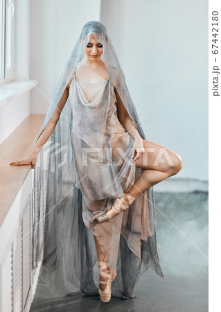 ballerina in scenic dress from airy voile working out in empty hall. 67442180