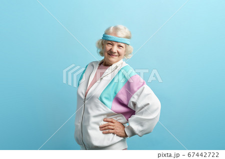 Optimistic elder female trainer dressed in sports suit and headband isolated Optimistic elder female trainer dressed in sports suit and headband isolated 67442722