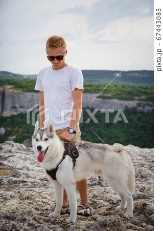 hiker with siberian husky dog looking at beautiful hiker with siberian husky dog looking at beautiful 67443083