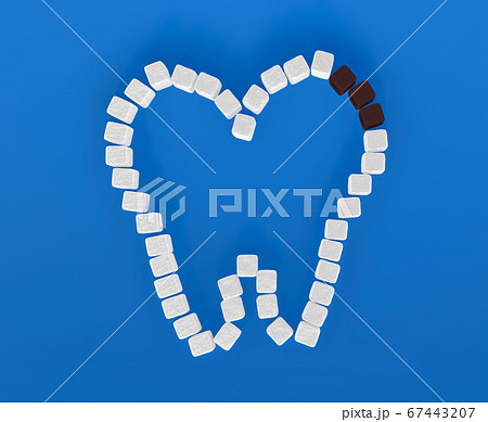 Tooth from sugar cubes on blue background, some brown sugar cubes, concept for sweet tooth, caries. Sugar is the cause of tooth decay. 3d render 67443207