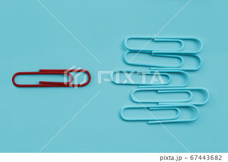 Business minimal concept as a group of paperclip on blue pastel background with one individual in the opposite direction. The idea about the business leadership, think different. 67443682