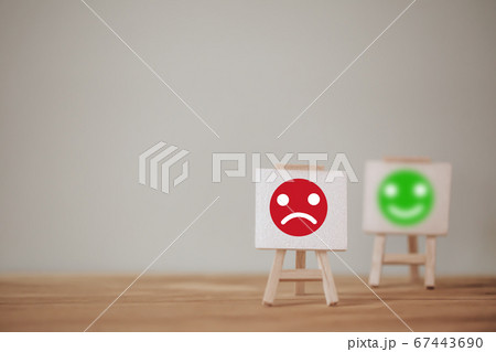 Satisfaction survey concept: Sign stand a sad face and a smiley face on wood table. depicts the best excellent business services rating customer experience.; Satisfaction survey concept: Sign stand a sad face and a smiley face on wood table. depicts the best excellent business services rating customer experience.; 67443690