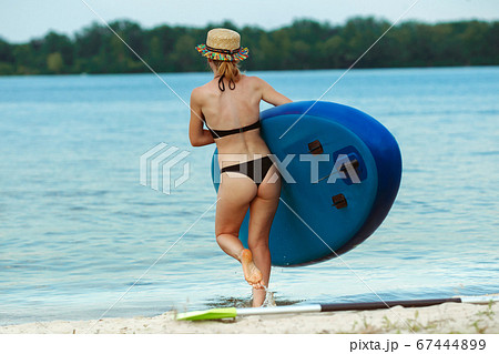 Young attractive woman carries paddle board, SUP. Active life, sport, leisure activity concept 67444899