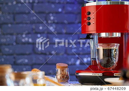 Red coffee machine with a glass on kitchen counter 67448209