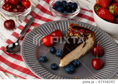 Vanilla cheesecake with chocolate top and berries 67448265