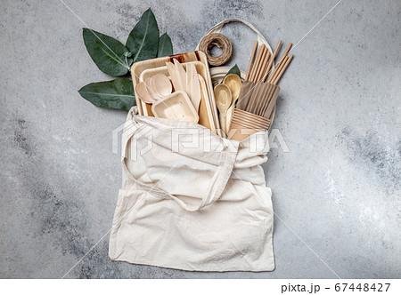Eco craft paper and wooden tableware. Paper cups, dishes, bag, plates and wooden cutlery in linen bag. Recycling or eco-friendly concept 67448427