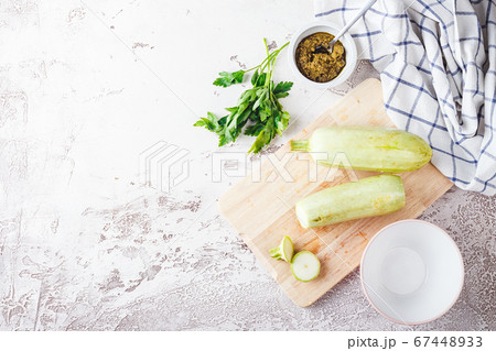 Fresh zucchini on a wooden board with a knife Fresh zucchini on a wooden board with a knife 67448933