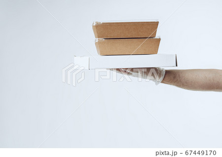 Courier hands in latex gloves giving packed food delivery Courier hands in latex gloves giving packed food delivery 67449170