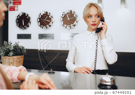 Female receptionist in hotel talking on the phone at work 67449201