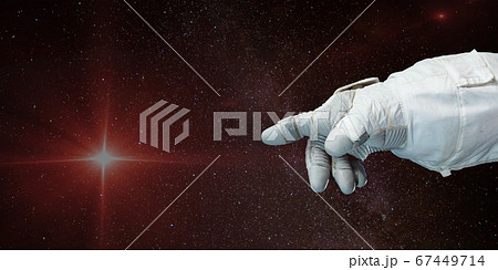 Astronaut hand pointing toward the star with 67449714