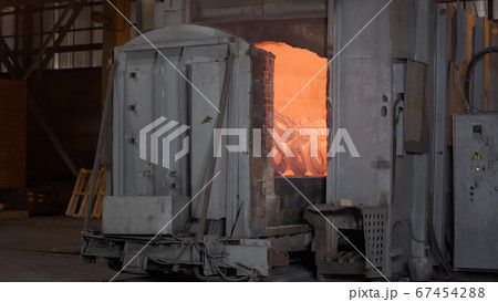 Robotic retractable furnace with red-hot metal workpieces in foundry. Room for manufacture of metal products by casting. Casting shop for gassified models. Heavy industry concept 67454288