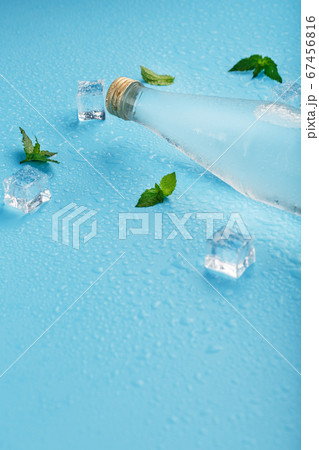 A bottle of ice water, ice cubes, drops and mint A bottle of ice water, ice cubes, drops and mint 67456816