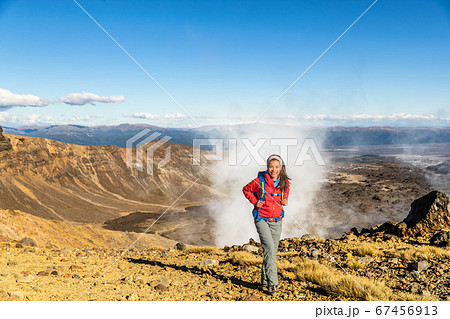 New Zealand Tongariro Alpine Crossing Hiking trek hiker woman with bag and outdoor jacket tramping in volcanic steam vents fumaroles background. Summer travel vacation adventure trekking girl hike New Zealand Tongariro Alpine Crossing Hiking trek hiker woman with bag and outdoor jacket tramping in volcanic steam vents fumaroles background. Summer travel vacation adventure trekking girl hike 67456913
