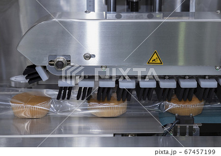 baked bread in food grade plastic bag on conveyor belt moves to seal in packing machine at production line of bakery manufacturing factory. food processing and industry concept 67457199