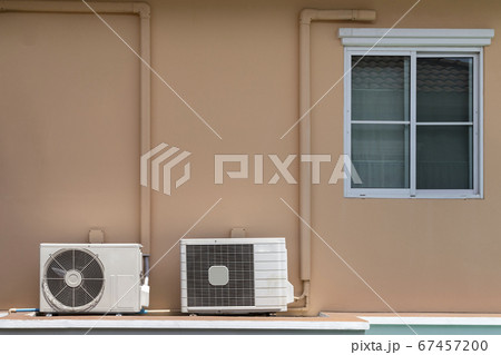 two types of home air conditioner compressor coil installation at the balcony under the window of the house. 67457200