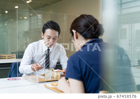 アクリルパーティションをはさんで食事する人々　飲食店の感染対策 67458576