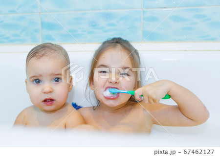 little girls brush their teeth in the bathroom. portrait of children with a toothbrush little girls brush their teeth in the bathroom. portrait of children with a toothbrush 67462127