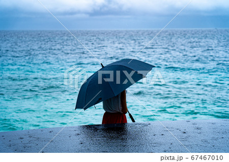 雨降る海上で傘をさす女性　モルディブの海とインフィニティプール 67467010
