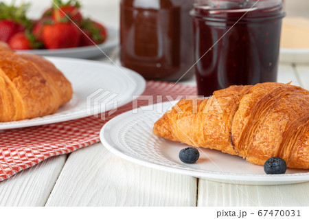 Fresh croissant decorated with berries on white wooden board Fresh croissant decorated with berries on white wooden board 67470031