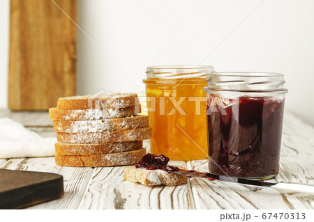 Slice of bread covered with fruit jam on wooden board Slice of bread covered with fruit jam on wooden board 67470313