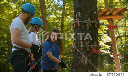 Extreme rope adventure - instructor explaining to a couple how to use their insurance hooks Extreme rope adventure - instructor explaining to a couple how to use their insurance hooks 67470921