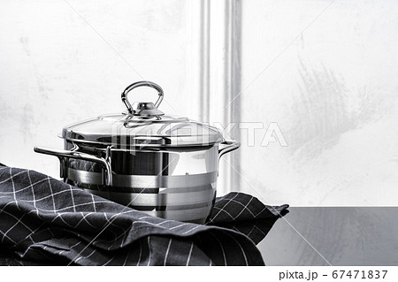 Aluminum cookware on black induction stove against grey wall Aluminum cookware on black induction stove against grey wall 67471837