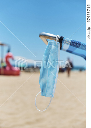 surgical mask hanging on a deck chair on the beach surgical mask hanging on a deck chair on the beach 67473716