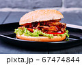 Fresh burger over wooden table and dark background. Front view 67474844