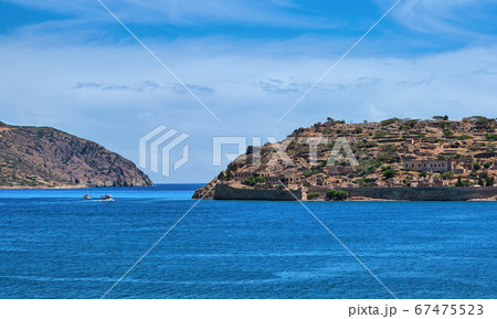 View of west bank of Spinalonga island and Venetian fortress on clear sunny summer day, Crete, Greece View of west bank of Spinalonga island and Venetian fortress on clear sunny summer day, Crete, Greece 67475523