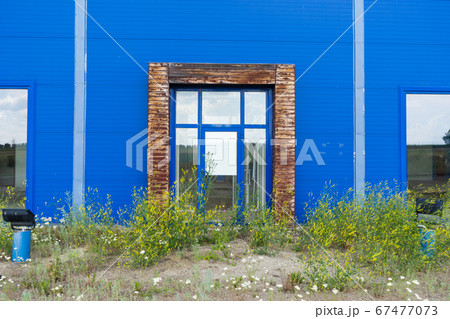 overgrown entrance to an abandoned shopping center building overgrown entrance to an abandoned shopping center building 67477073