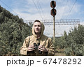a man with binoculars in his hands looks into the distance. abandoned old railway  67478292