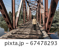 man stands on an abandoned railway bridge.  67478293