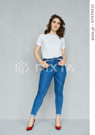Positive girl in jeans, t-shirt and stilettos Positive girl in jeans, t-shirt and stilettos 67479410