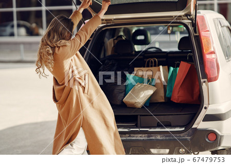 Woman by the car with a shopping bags Woman by the car with a shopping bags 67479753