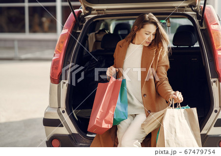Woman by the car with a shopping bags 67479754