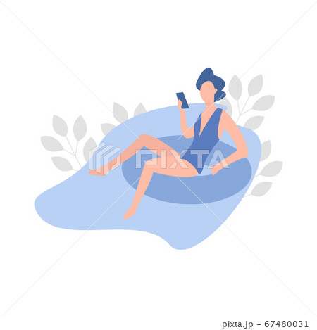 Young Woman Sunbathing in the Swimming Pool and playing with her phone 67480031