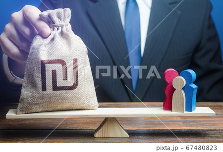 Man puts Israeli shekel money bag on scales with family figures. Social assistance benefits, financial support. Charitable donations. Investments in human capital, culture and social projects. Man puts Israeli shekel money bag on scales with family figures. Social assistance benefits, financial support. Charitable donations. Investments in human capital, culture and social projects. 67480823