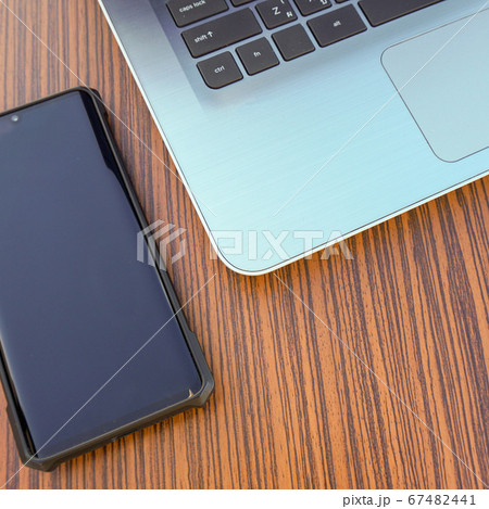Computer notebook with black smartphone and a blue Computer notebook with black smartphone and a blue 67482441