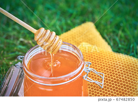 Open jar of fresh honey and honeycombs on the Open jar of fresh honey and honeycombs on the 67482850