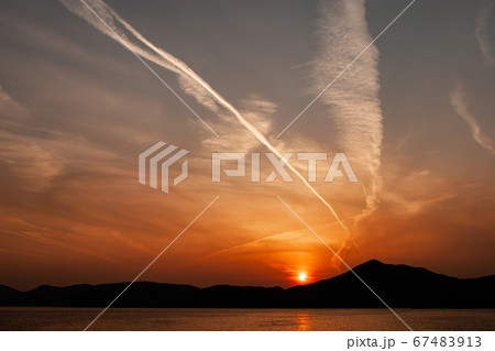 夕焼けと飛行機雲のある瀬戸内海の夕景 夕焼けと飛行機雲のある瀬戸内海の夕景 67483913