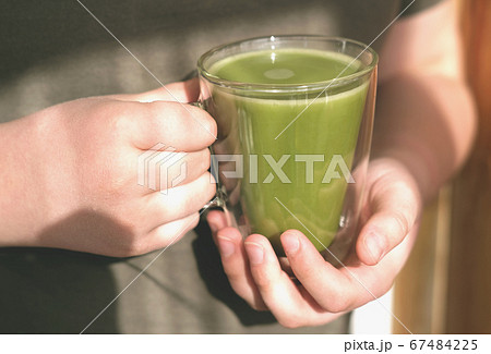 matcha oatmeal milk in human hands matcha oatmeal milk in human hands 67484225