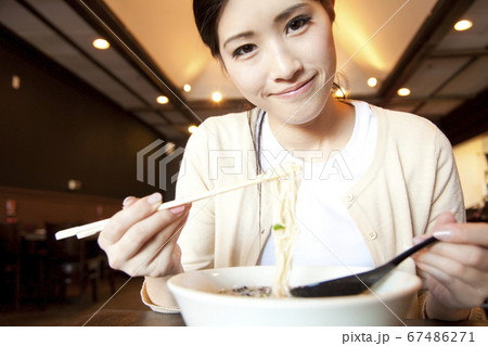 ラーメンを食べる女性客 67486271